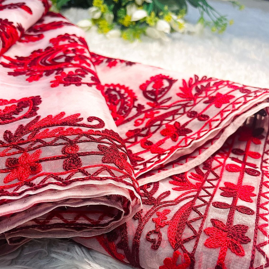 Close-up of detailed pasham thread embroidery on red organza dupatta showing intricate craftsmanship.